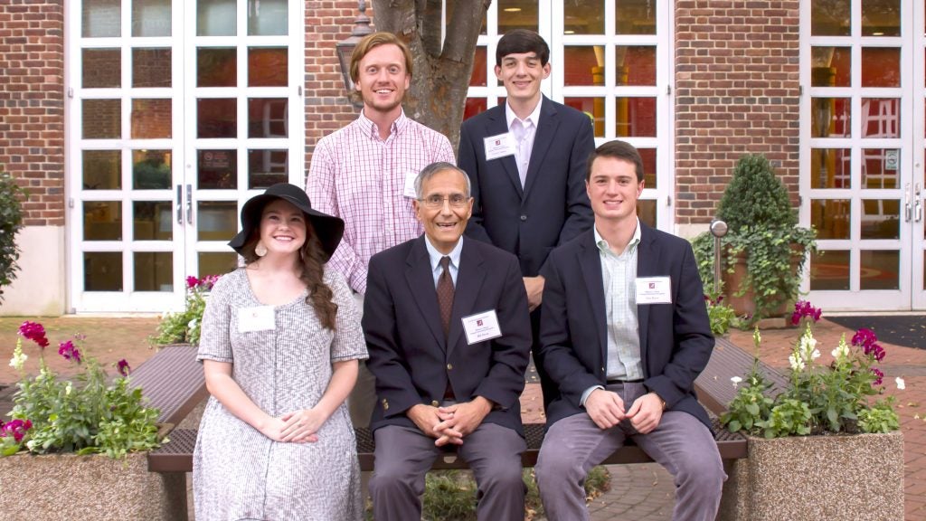 Bill Decas posing for photo around scholarship recipients