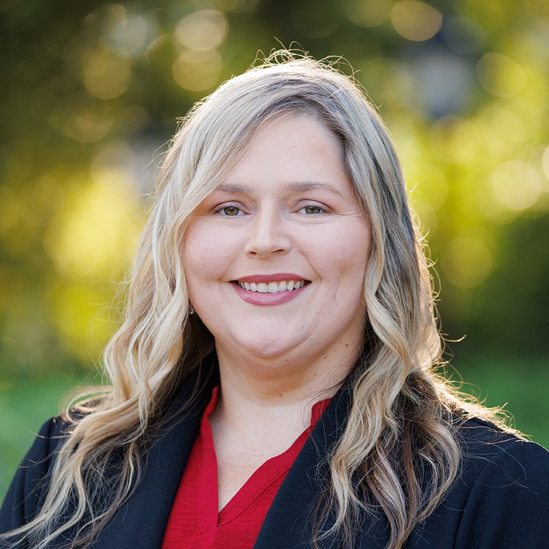 A white woman poses for a photo outdoors