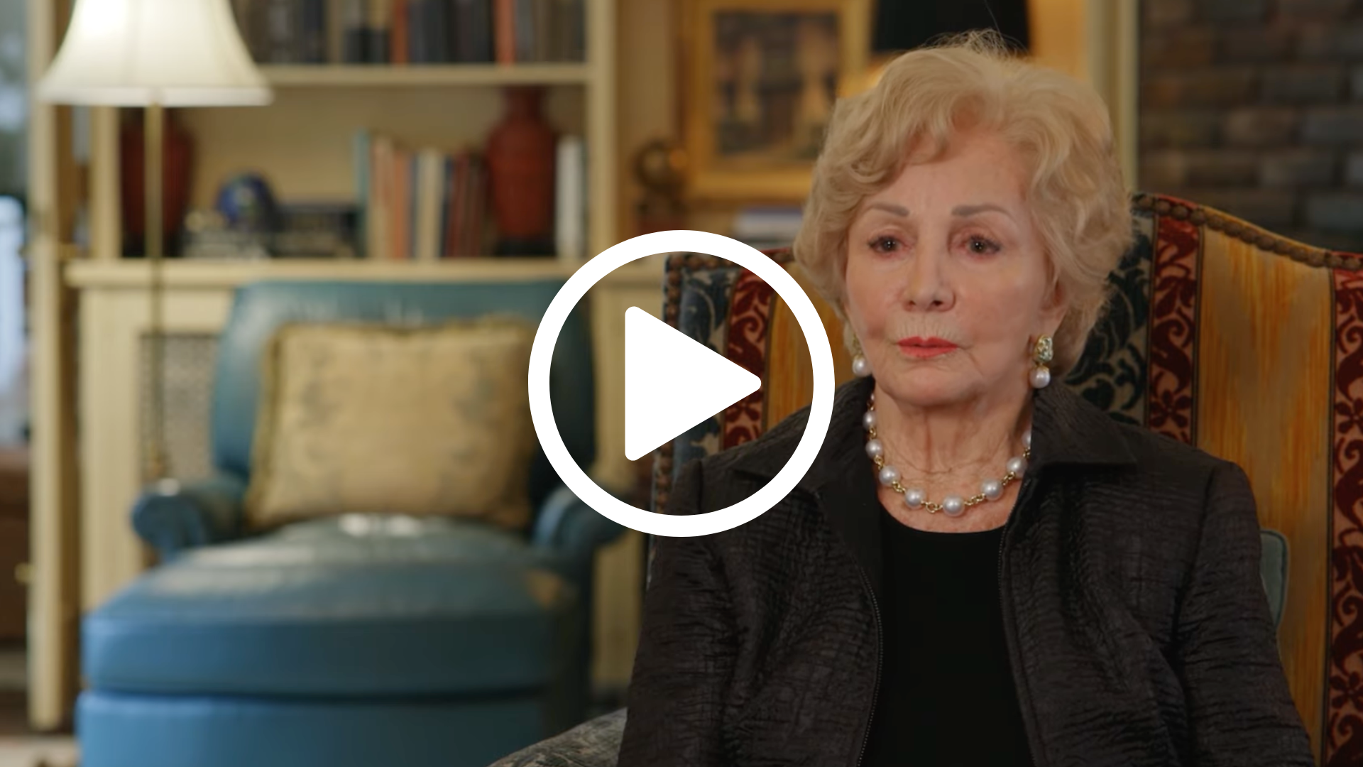 A woman sits in a chair and answers questions